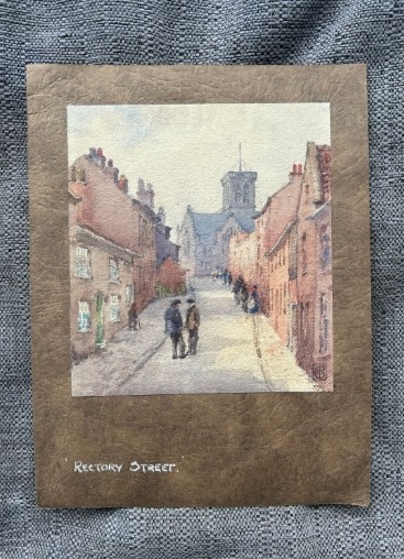 An antique watercolour painting depicting figures on a sloping street flanked by brick buildings leading towards a church tower. View VII