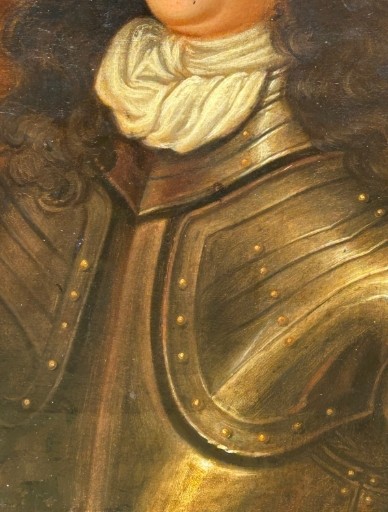 A seventeenth-century oil painting on canvas depicting a gentleman in dark plate armour, set within an oval spandrel inside a decorative giltwood frame. View IX