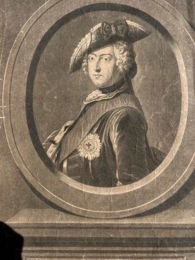An 18th-century monochrome mezzotint print depicting a bust portrait of Frederick King of Prussia set within a stone oval frame. View V