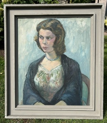 A mid-century oil painting on canvas depicting a seated woman wearing a patterned dress, blue necklace, and dark shawl, framed in a grey wooden frame.