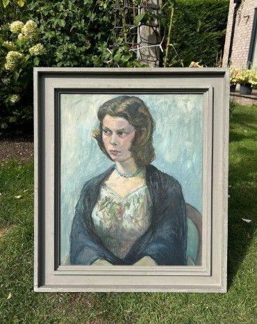 A mid-century oil painting on canvas depicting a seated woman wearing a patterned dress, blue necklace, and dark shawl, framed in a grey wooden frame. View II