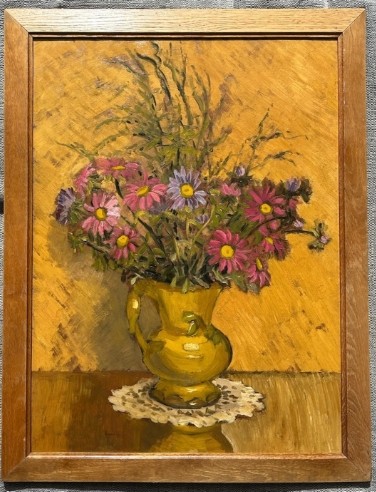 A mid-20th century oil painting on board featuring pink and purple flowers in a yellow pitcher against a textured ochre background, presented in a wooden frame.