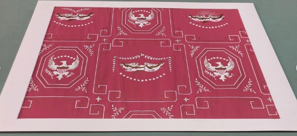 Crimson red hand-printed wallpaper panel featuring white and gold American eagle motifs within octagonal panels, laurel swags, and geometric borders. View XIV