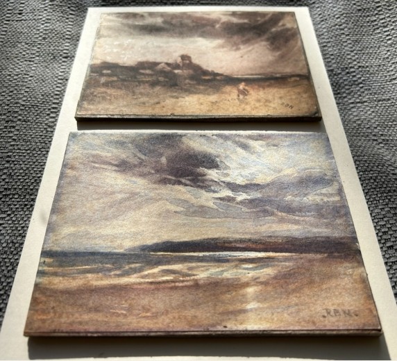 A pair of late 19th-century watercolour paintings depicting a Scottish rural landscape and a coastal shoreline, both initialled RBN in the lower corner. View X
