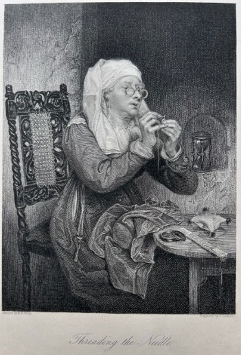 A monochrome nineteenth-century steel engraving depicting an elderly woman wearing spectacles and a headscarf threading a needle while seated at a small wooden table.