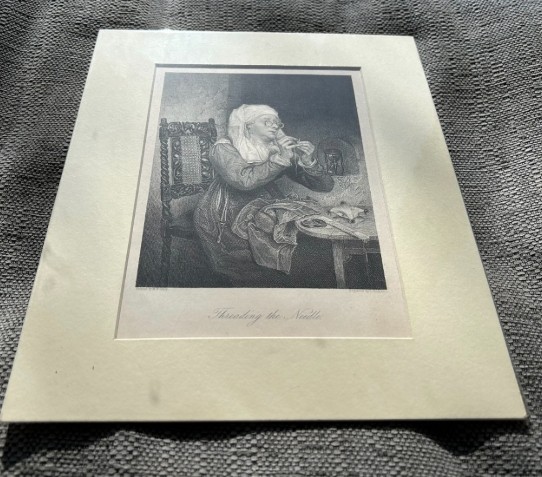 A monochrome nineteenth-century steel engraving depicting an elderly woman wearing spectacles and a headscarf threading a needle while seated at a small wooden table. View XI