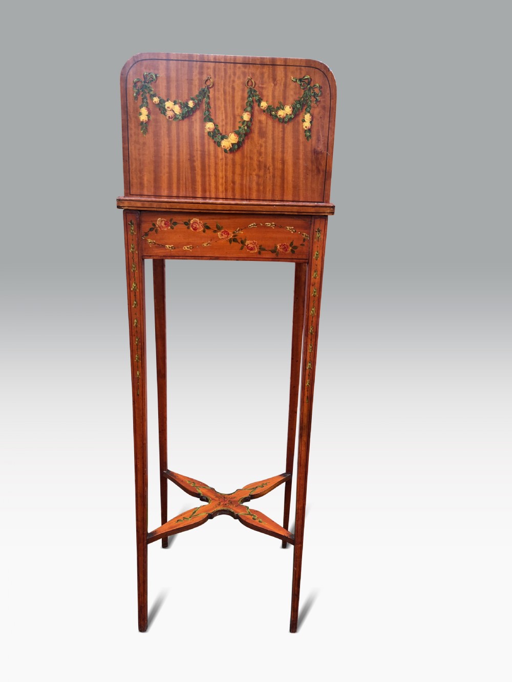 Late 19th-century satinwood standing bookstand with hand-painted rose garlands, vertical book divisions, tapered legs, and an X-shaped stretcher. View III