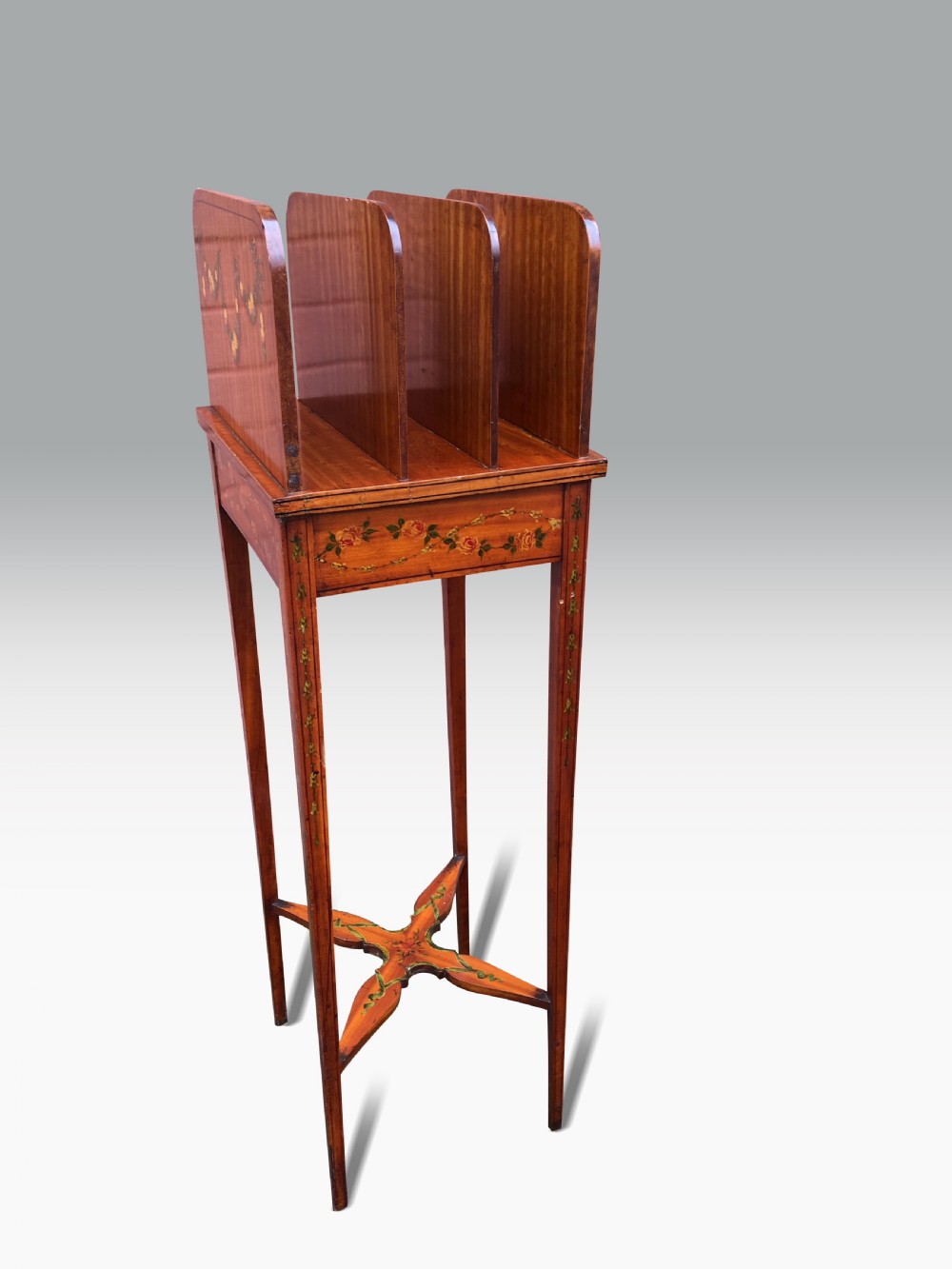 Late 19th-century satinwood standing bookstand with hand-painted rose garlands, vertical book divisions, tapered legs, and an X-shaped stretcher. View IV