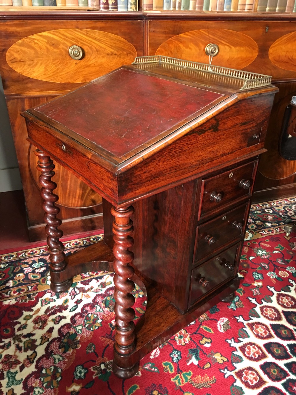 A William IV dark rosewood Davenport writing desk featuring carved barley twist front supports, a sloped writing top, a brass gallery, and side-opening drawers. View II