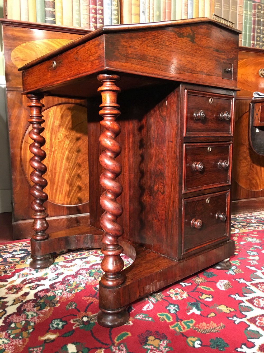 A William IV dark rosewood Davenport writing desk featuring carved barley twist front supports, a sloped writing top, a brass gallery, and side-opening drawers. View III