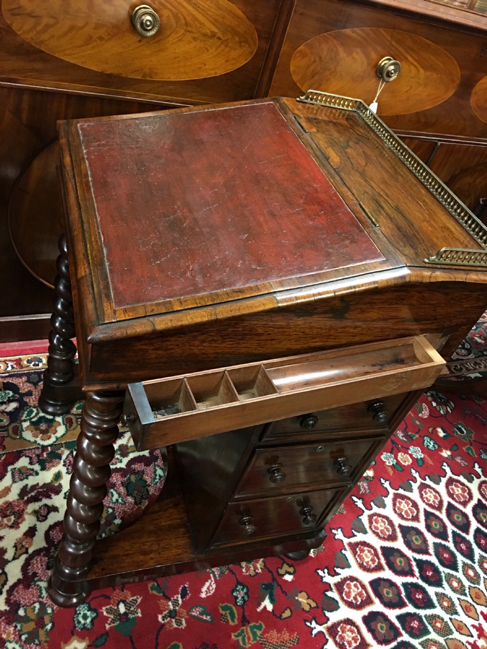 A William IV dark rosewood Davenport writing desk featuring carved barley twist front supports, a sloped writing top, a brass gallery, and side-opening drawers. View V