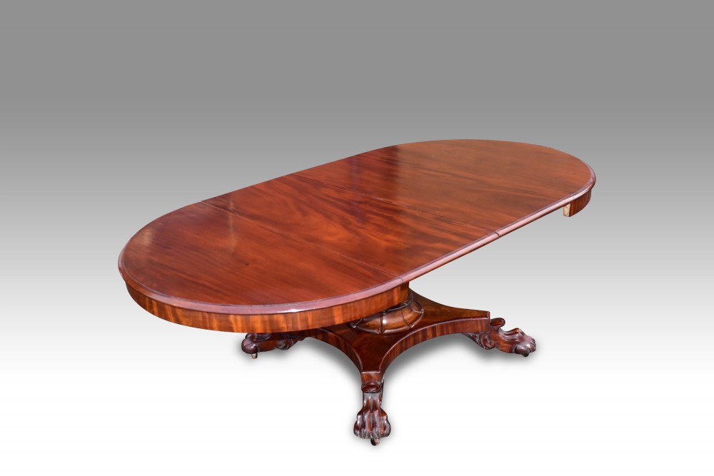 A FINE REGENCY MAHOGANY CIRCULAR EXTENDING DINING TABLE.