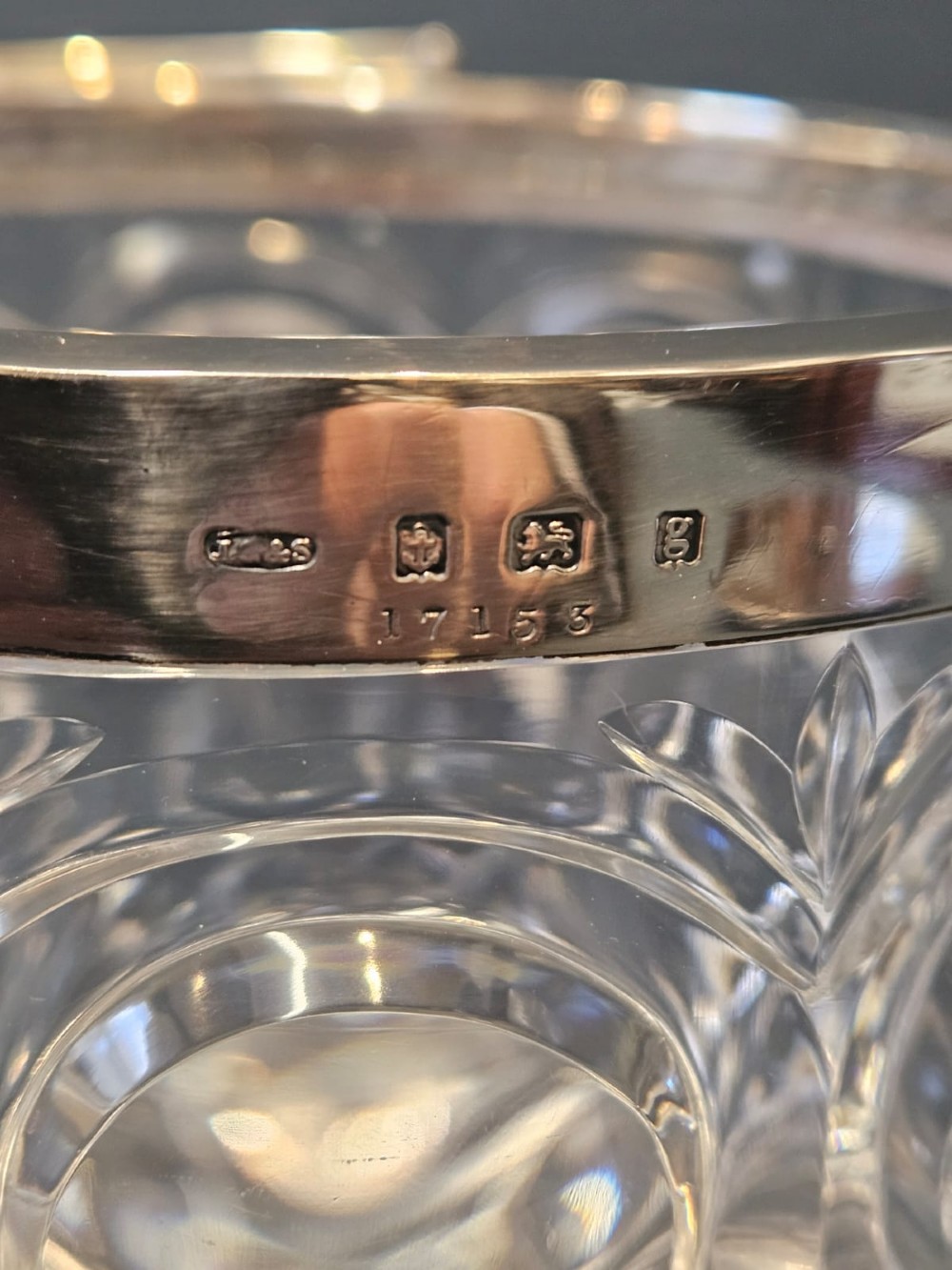 A clear cut crystal ice pail featuring an arched decorative motif, fitted with a silver rim and a slender swing handle. View VIII