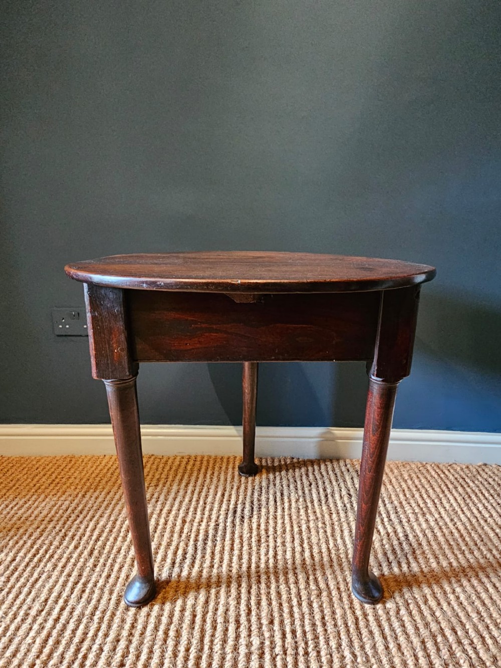 A round Georgian elm cricket table with three tapered legs terminating in pad feet and a triangular deep apron. View III