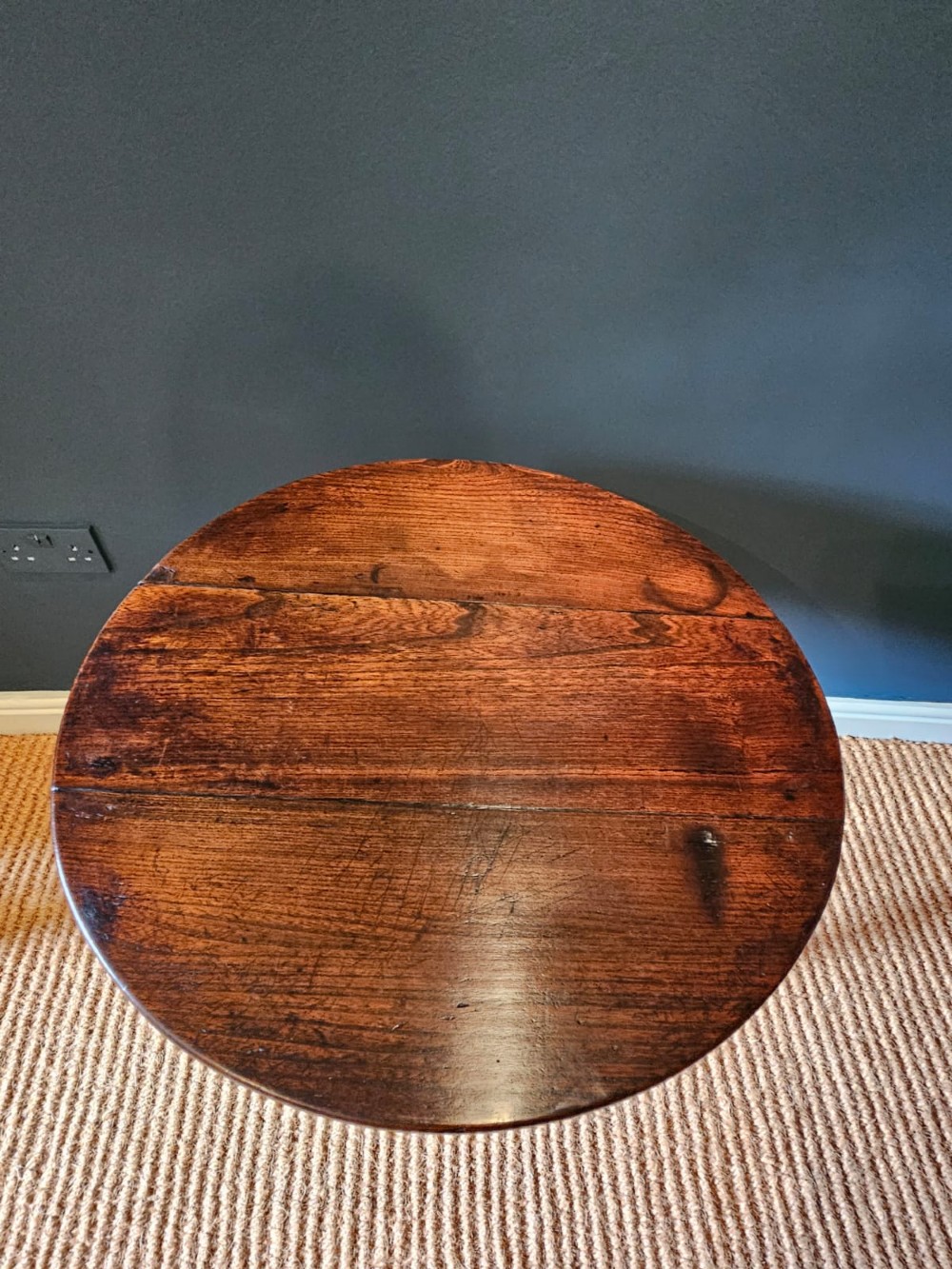 A round Georgian elm cricket table with three tapered legs terminating in pad feet and a triangular deep apron. View V