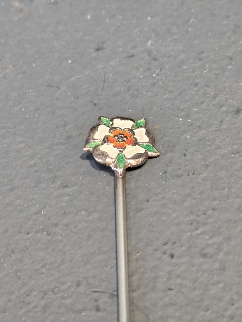 A set of eight silver cocktail sticks with colourful enamelled floral finials displayed inside a black silk and velvet-lined presentation box. View II