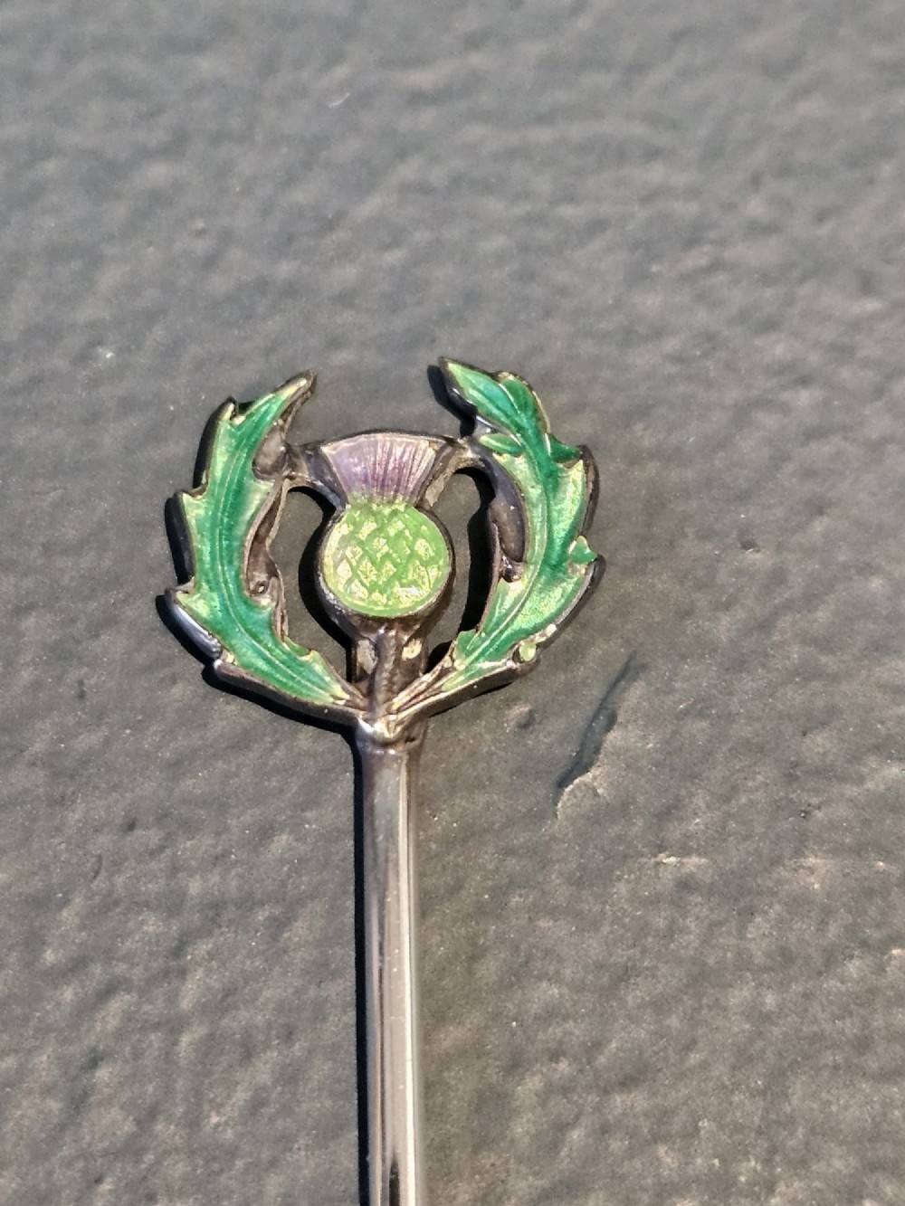 A set of eight silver cocktail sticks with colourful enamelled floral finials displayed inside a black silk and velvet-lined presentation box. View IV