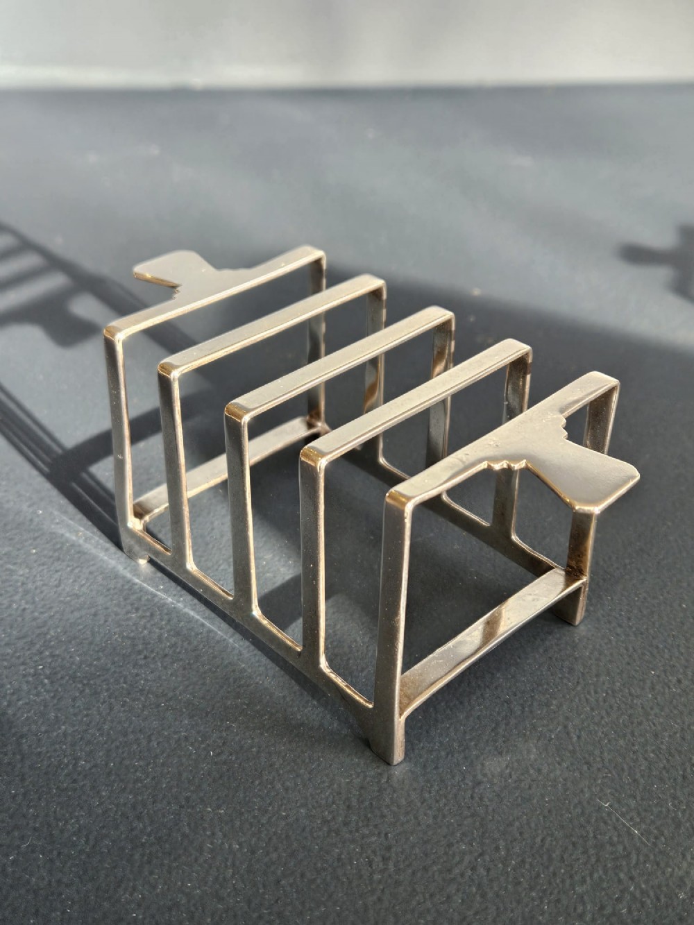 A matching pair of silver six-slice toast racks made by Mappin and Webb with geometric handles and stamped hallmarks. View III