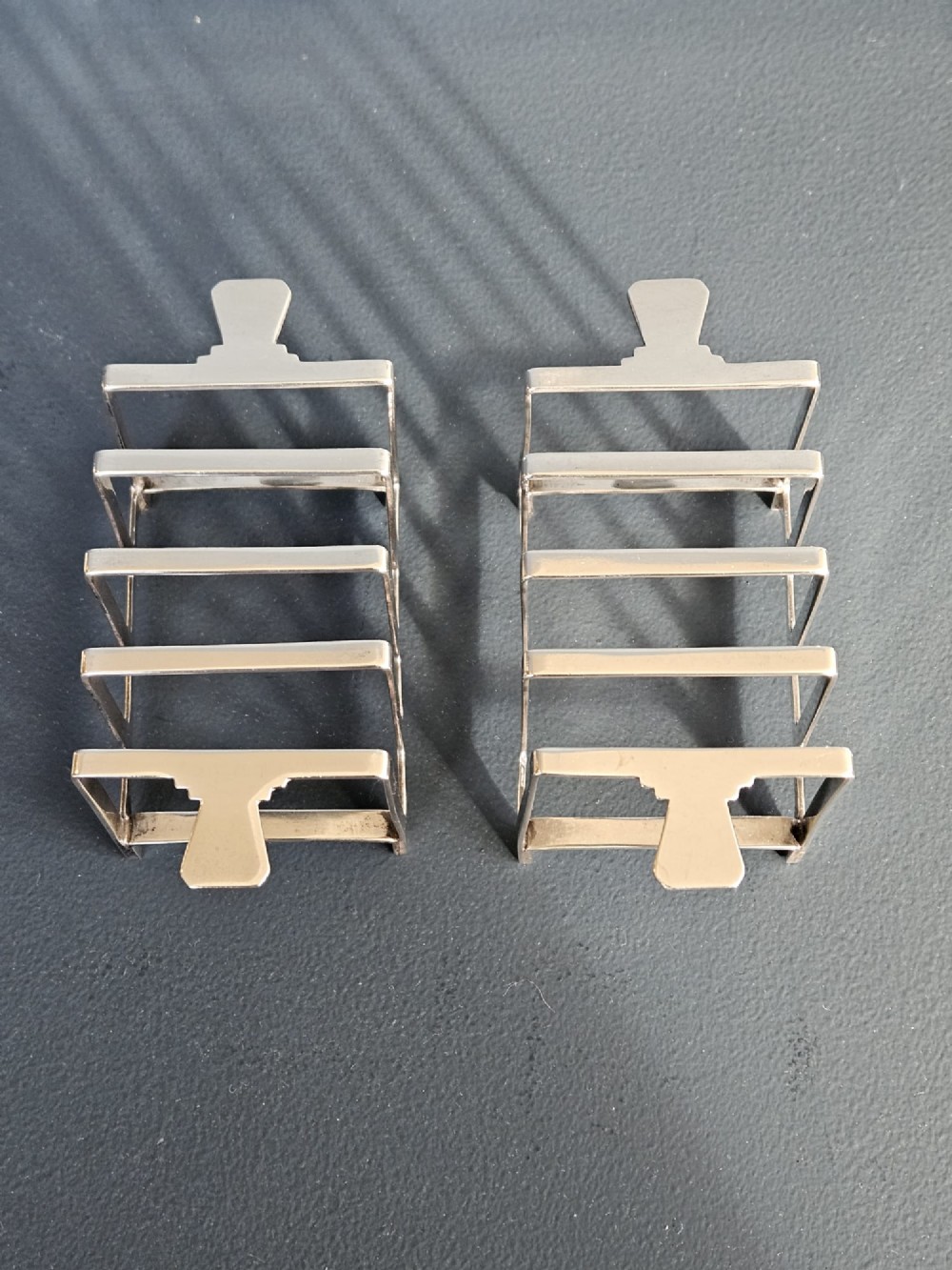 A matching pair of silver six-slice toast racks made by Mappin and Webb with geometric handles and stamped hallmarks. View VIII