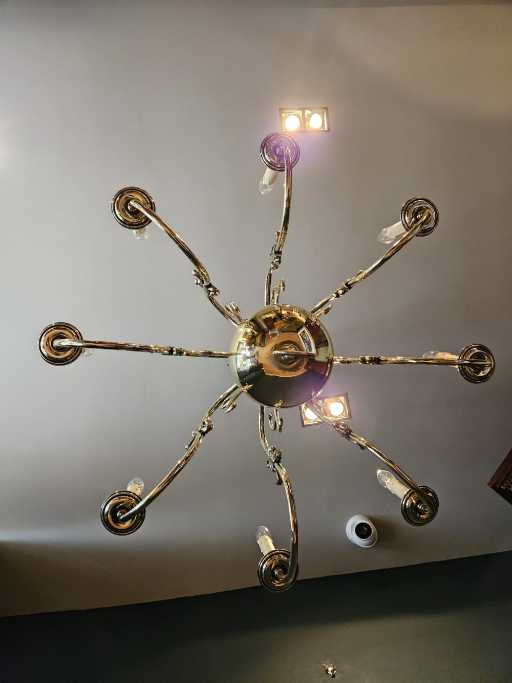 An Edwardian-style polished brass eight-arm chandelier featuring an eagle finial, central baluster stem, scrolling branches, and faux candle light sockets. View VIII