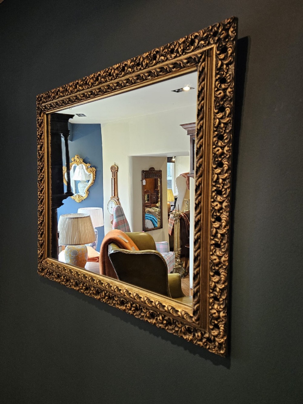 A large rectangular Victorian gilt mirror featuring a heavily carved timber frame with a gold leaf finish. View VII