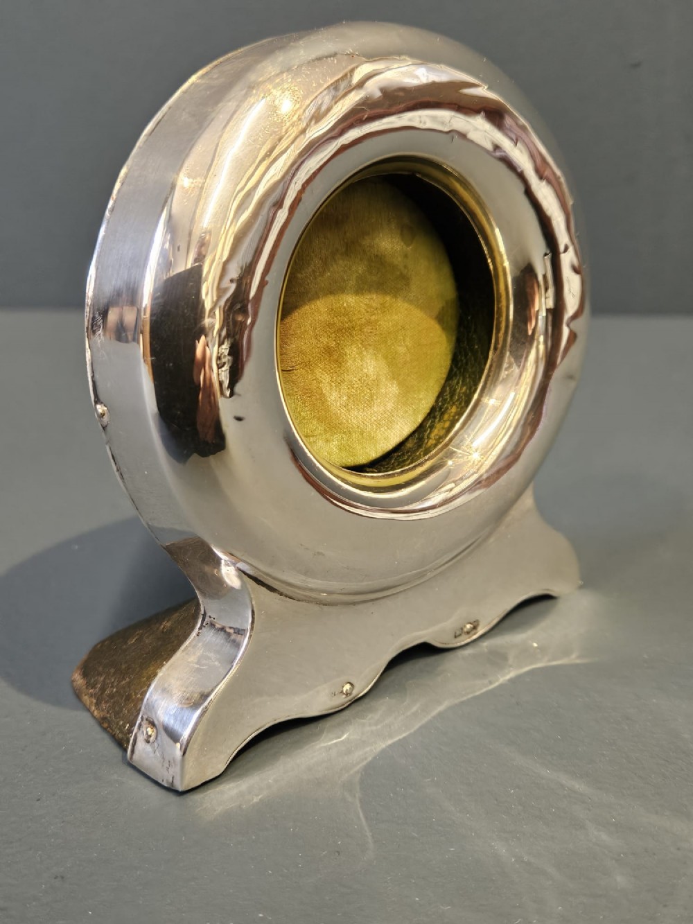 A circular sterling silver pocket watch holder with Chester hallmarks, featuring a recessed green velvet interior bezel and a shaped base. View II