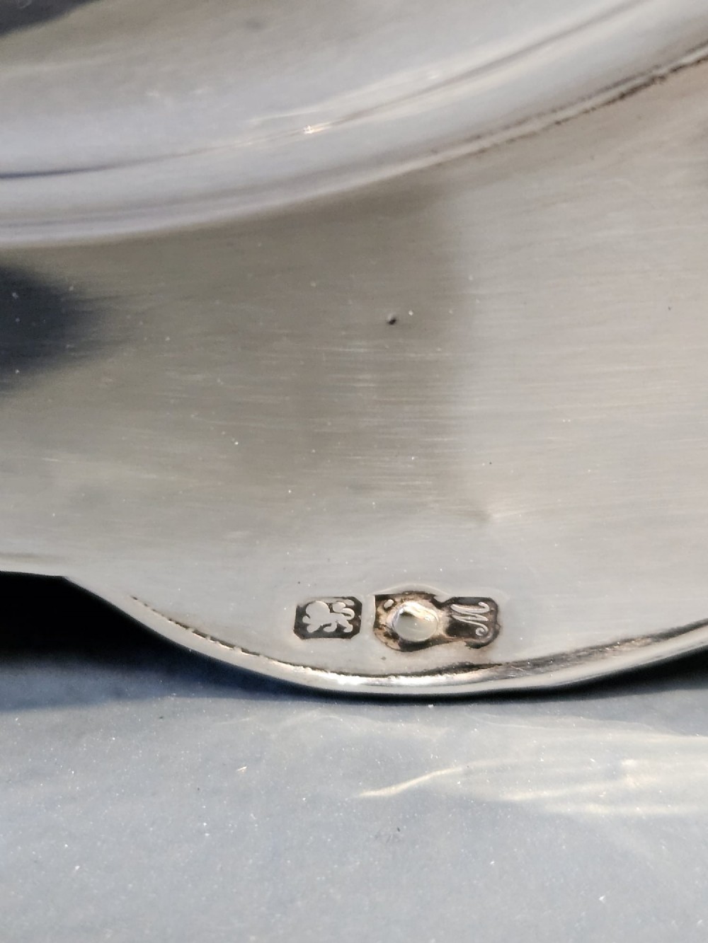 A circular sterling silver pocket watch holder with Chester hallmarks, featuring a recessed green velvet interior bezel and a shaped base. View III