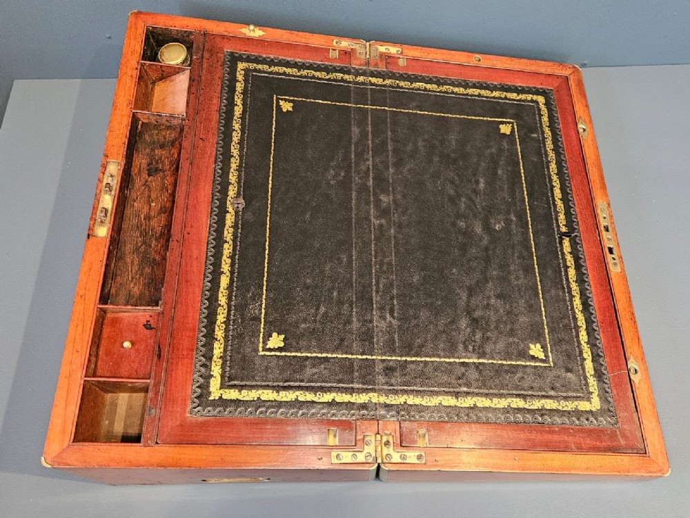 An open Victorian mahogany writing slope featuring a gold-tooled black leather insert, internal compartments, and an extended side drawer. View II
