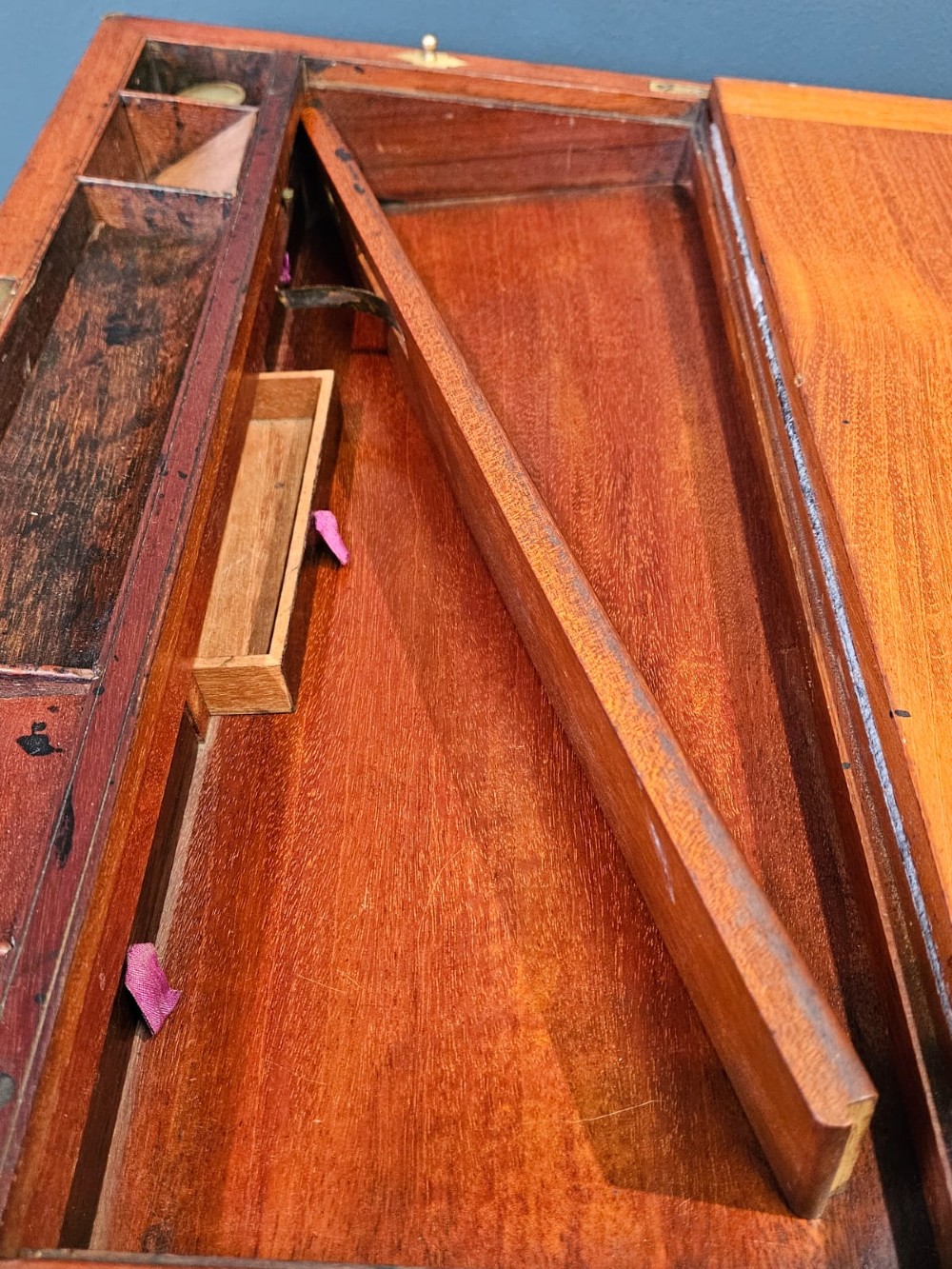 An open Victorian mahogany writing slope featuring a gold-tooled black leather insert, internal compartments, and an extended side drawer. View VI