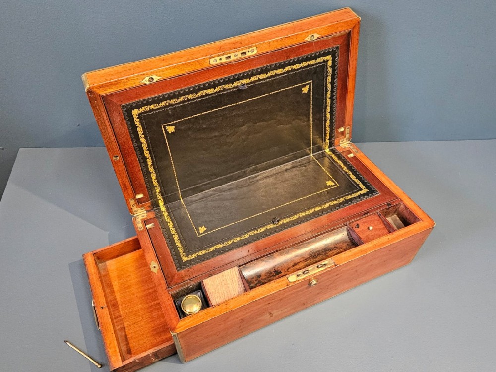 An open Victorian mahogany writing slope featuring a gold-tooled black leather insert, internal compartments, and an extended side drawer. View VII