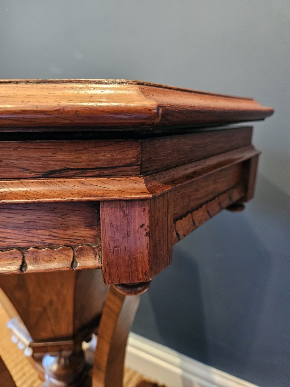 A William IV rosewood octagonal sewing work table featuring a tapered trumpet column supported by a carved quadform base with scroll feet. View II