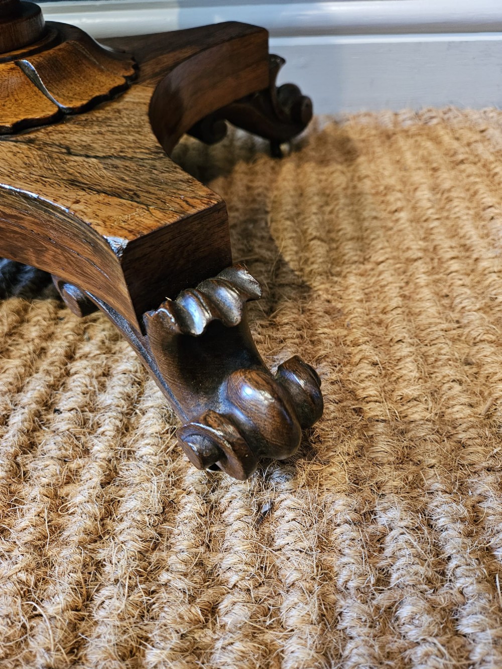 A William IV rosewood octagonal sewing work table featuring a tapered trumpet column supported by a carved quadform base with scroll feet. View IV