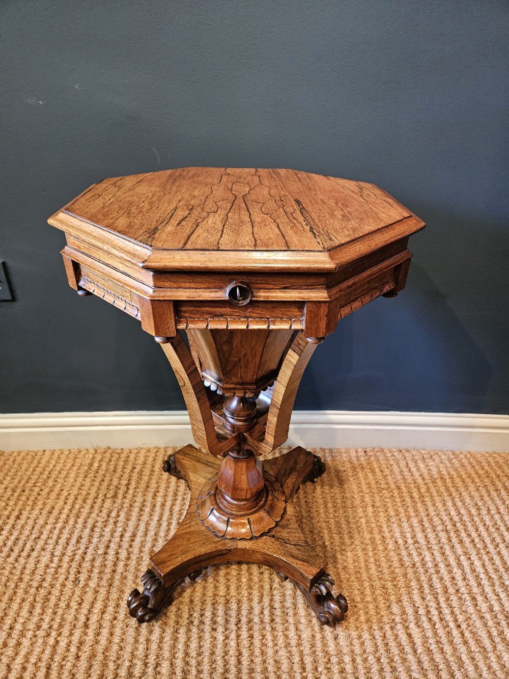 A William IV rosewood octagonal sewing work table featuring a tapered trumpet column supported by a carved quadform base with scroll feet. View VI