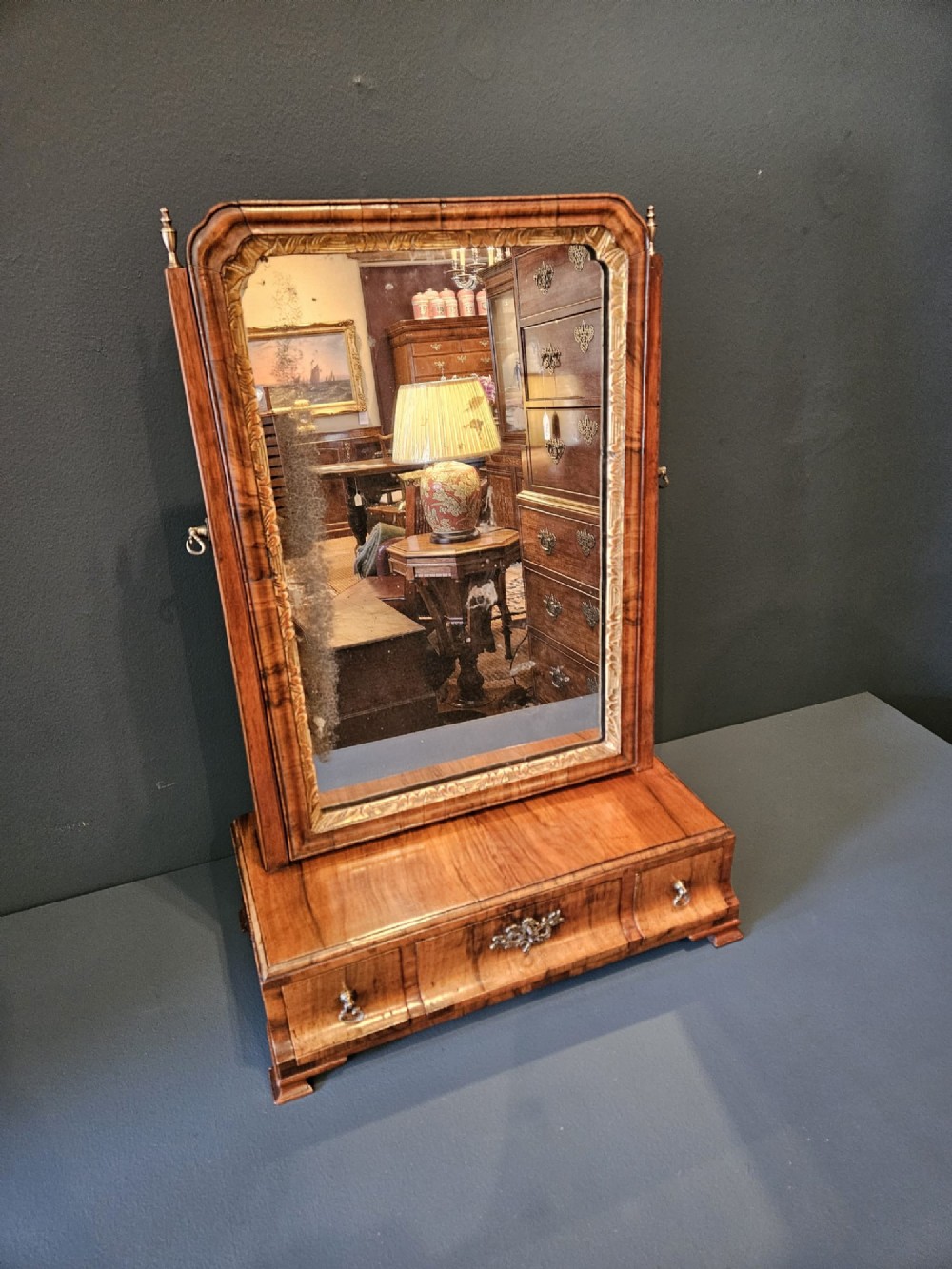 An 18th-century George II figured walnut toilet mirror featuring an adjustable frame with a gilded inner slip moulding above a single-drawer wooden base. View II