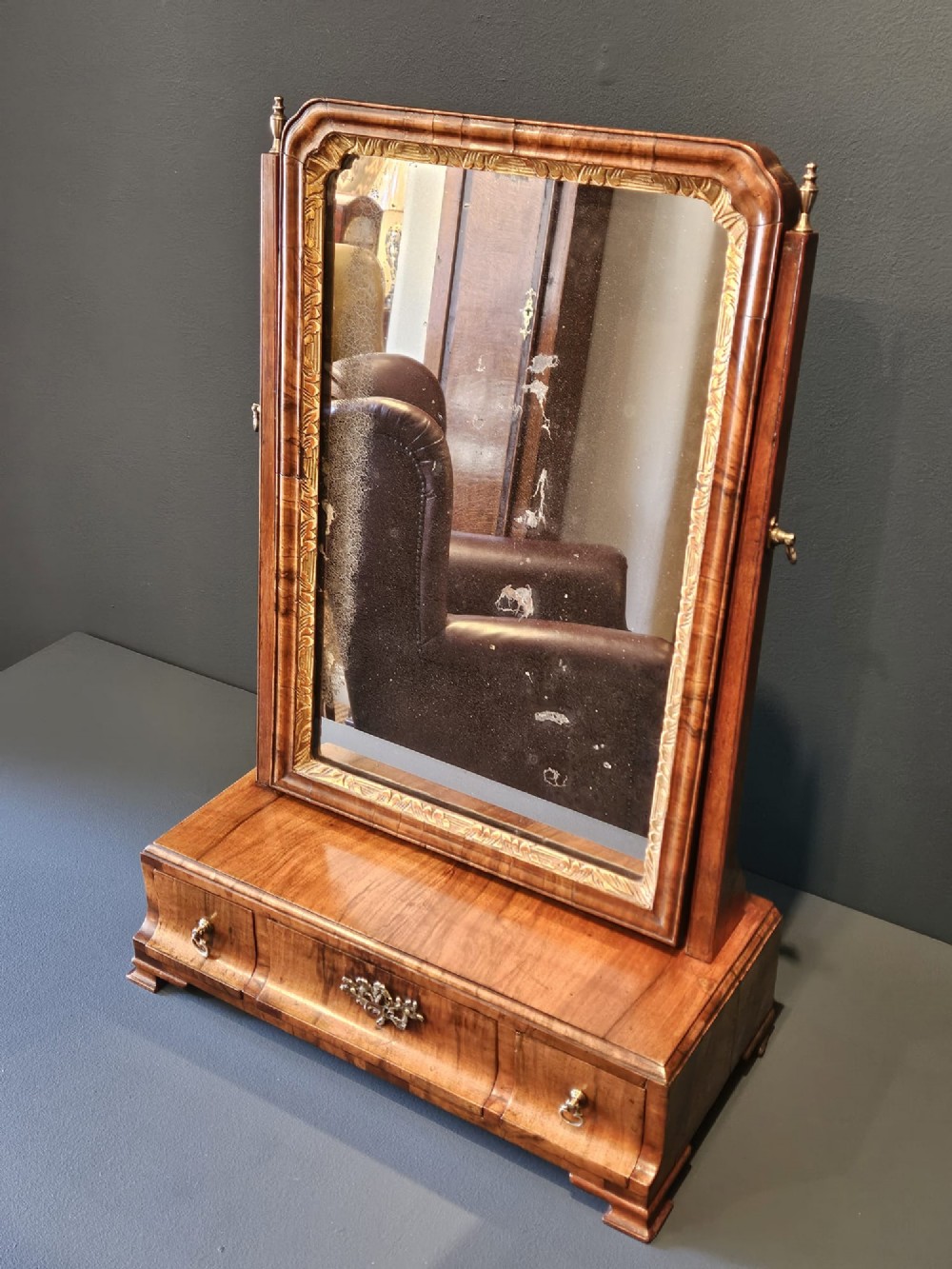 An 18th-century George II figured walnut toilet mirror featuring an adjustable frame with a gilded inner slip moulding above a single-drawer wooden base. View V