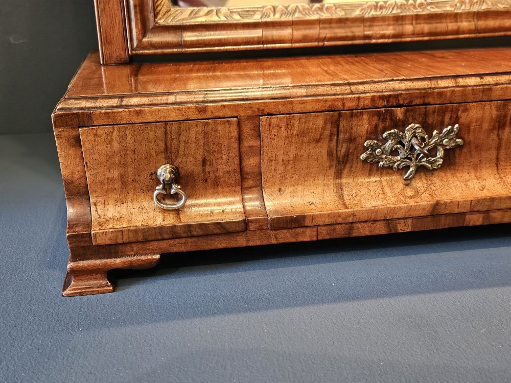 An 18th-century George II figured walnut toilet mirror featuring an adjustable frame with a gilded inner slip moulding above a single-drawer wooden base. View VI