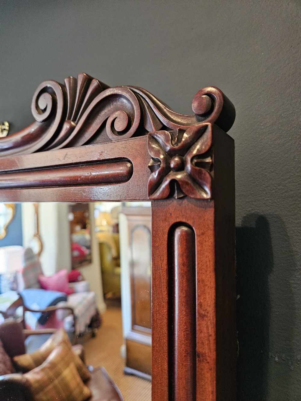 A rectangular Victorian mahogany wall mirror featuring a carved pediment crest and fluted side pillars. View V