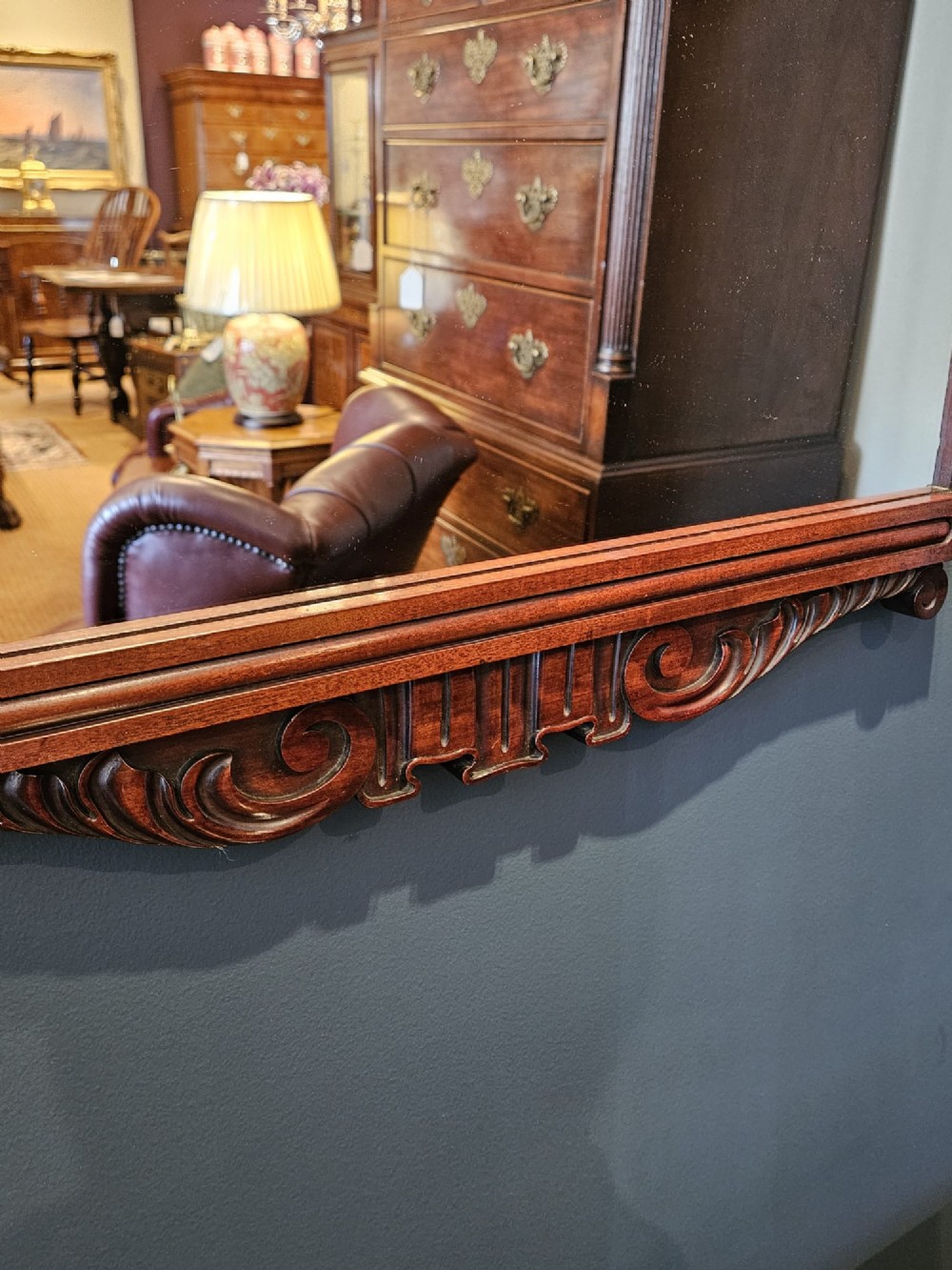 A rectangular Victorian mahogany wall mirror featuring a carved pediment crest and fluted side pillars. View VI
