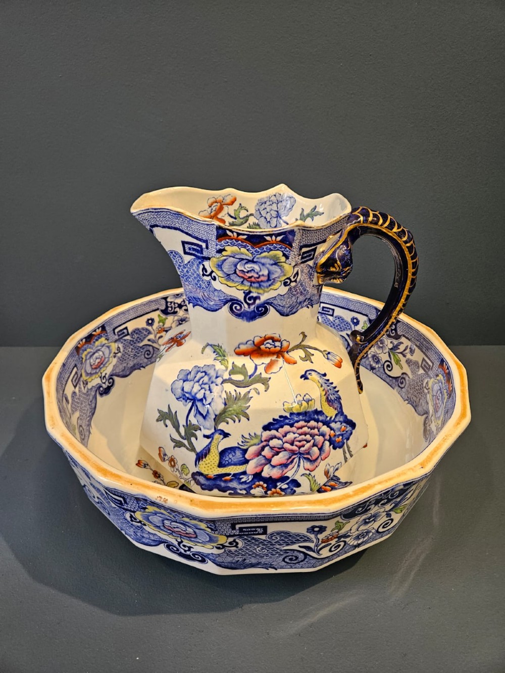 An octagonal Masons ironstone jug and matching wash basin decorated with polychrome floral Chinoiserie patterns and a cobalt blue gilded handle. View V