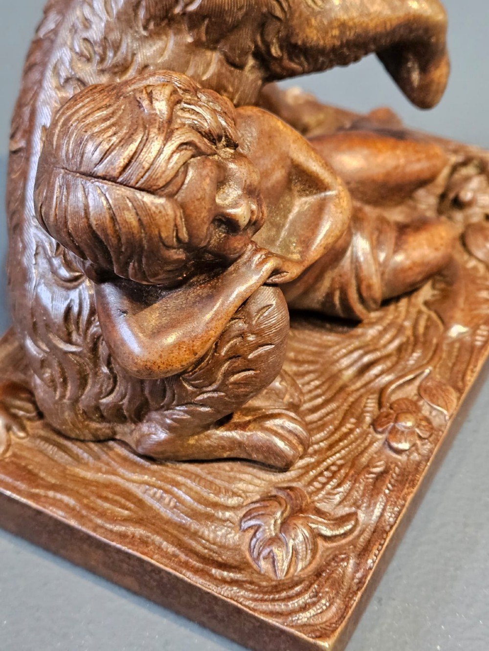 An Edwardian bronze sculpture depicting a sleeping child resting beside an alert dog on a rectangular relief base. View III