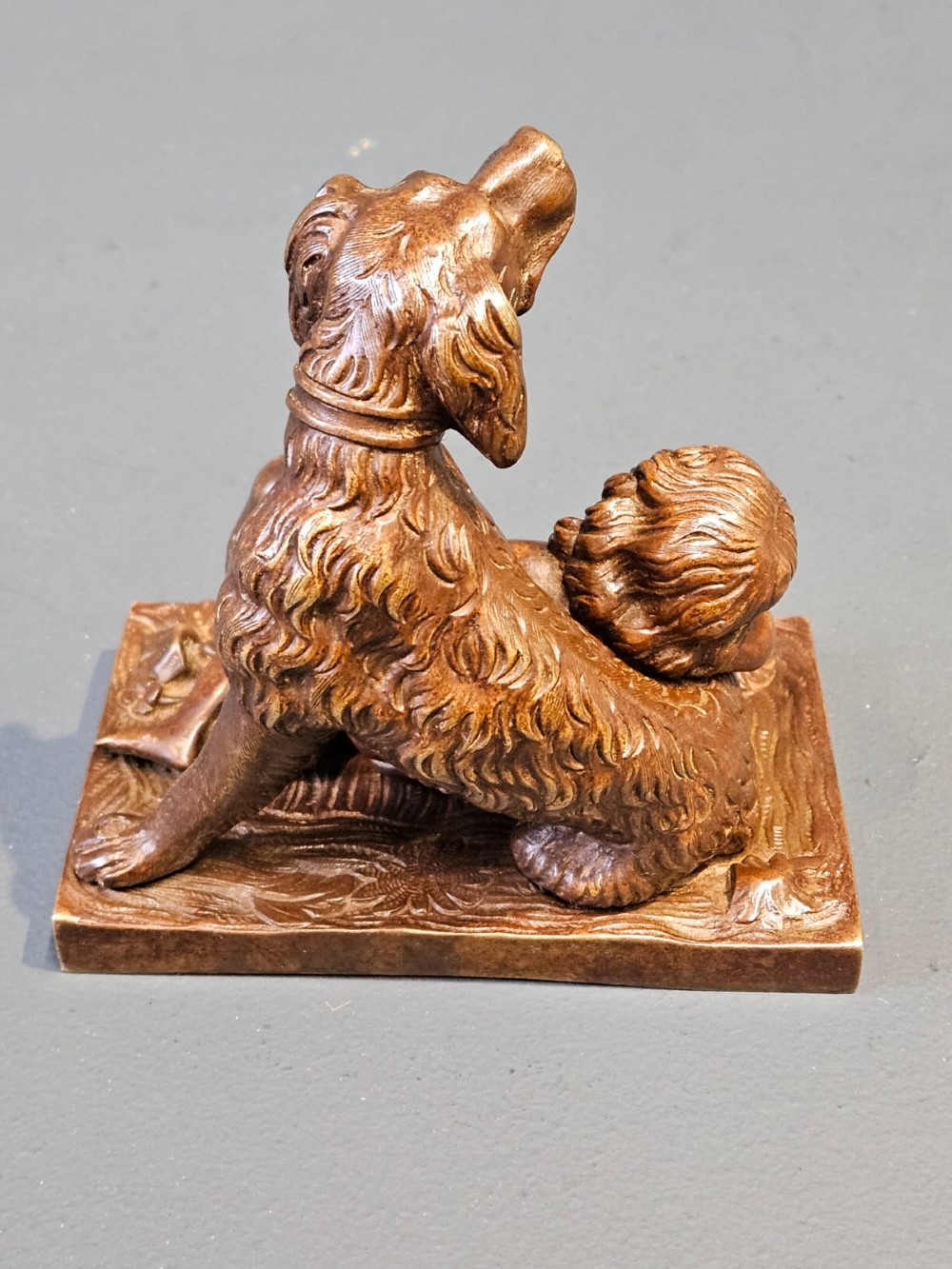 An Edwardian bronze sculpture depicting a sleeping child resting beside an alert dog on a rectangular relief base. View VIII
