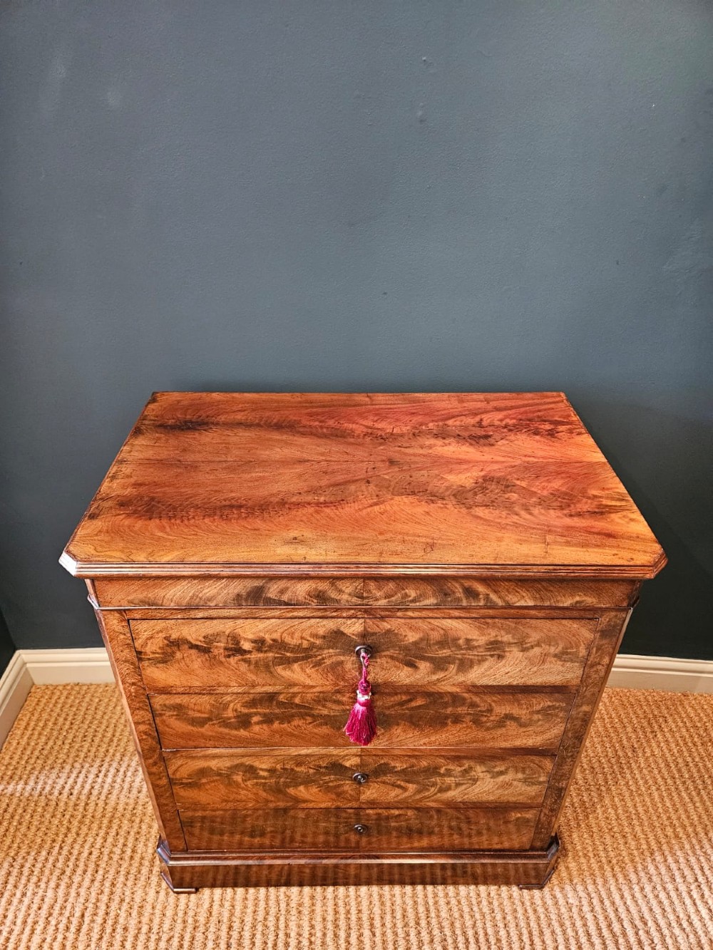 A 19th-century figured mahogany chest of drawers featuring four drawers, flame timber veneer pattern, and a solid plinth base. View V