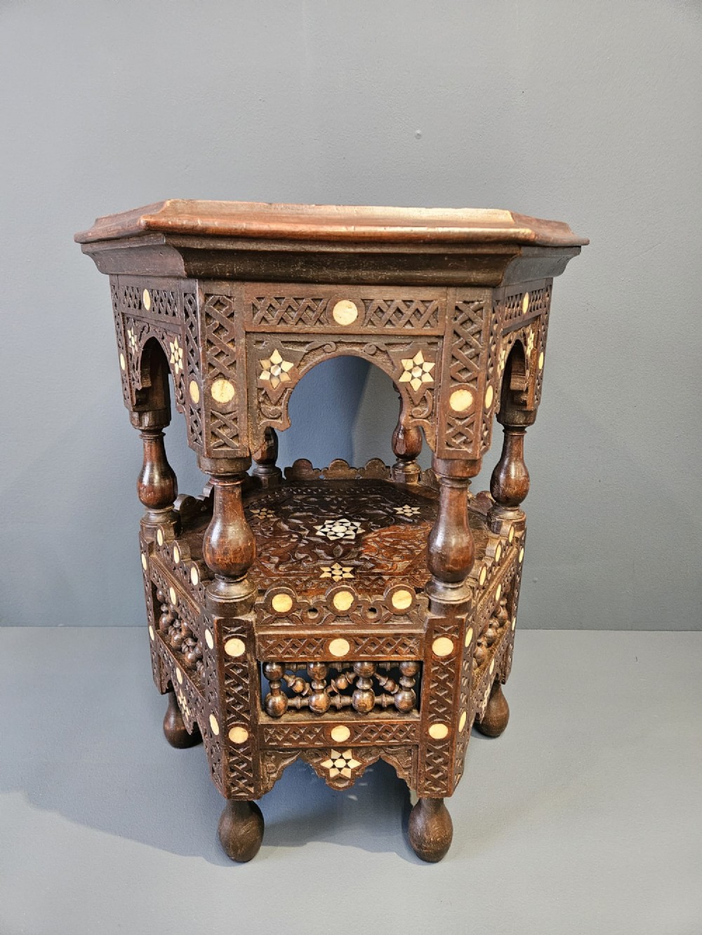 An octagonal dark wood Moorish table featuring carved geometric lattice panels, horseshoe arches, and inlaid bone star motifs. View II