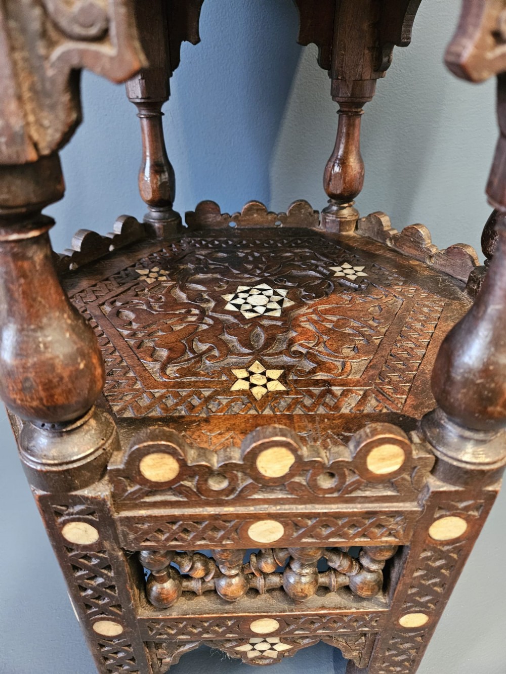 An octagonal dark wood Moorish table featuring carved geometric lattice panels, horseshoe arches, and inlaid bone star motifs. View IV