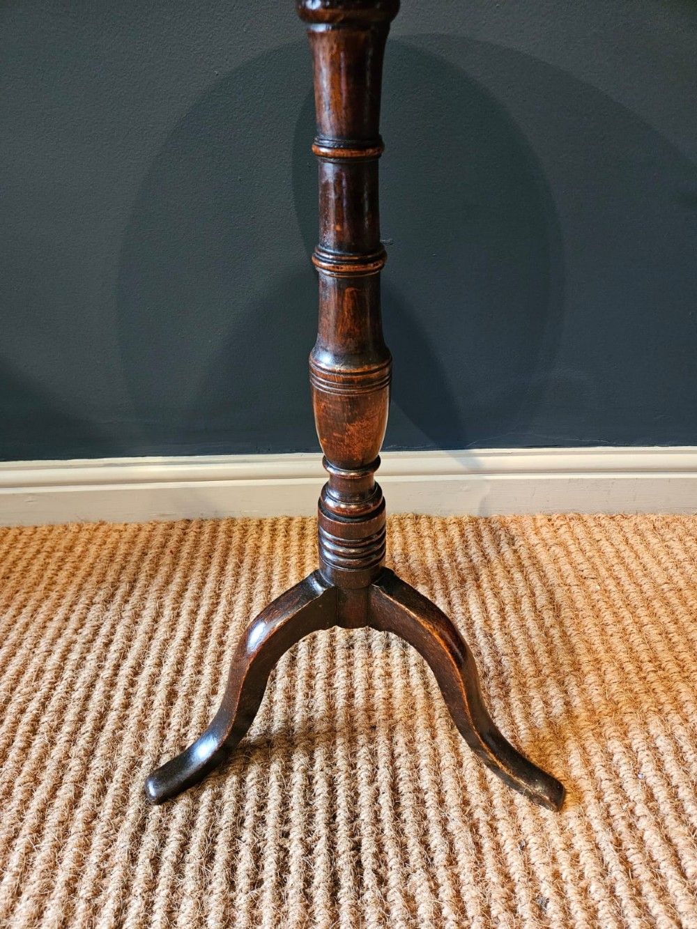 A small George III period oak tripod table featuring a circular top supported by a turned central column and three curved legs. View III