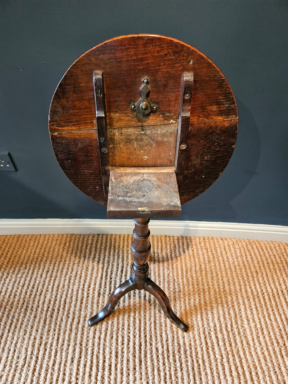 A small George III period oak tripod table featuring a circular top supported by a turned central column and three curved legs. View V