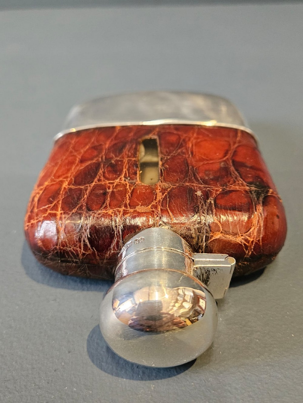 An antique silver hip flask partially encased in brown textured crocodile skin with a bayonet cap and removable base cup. View IV