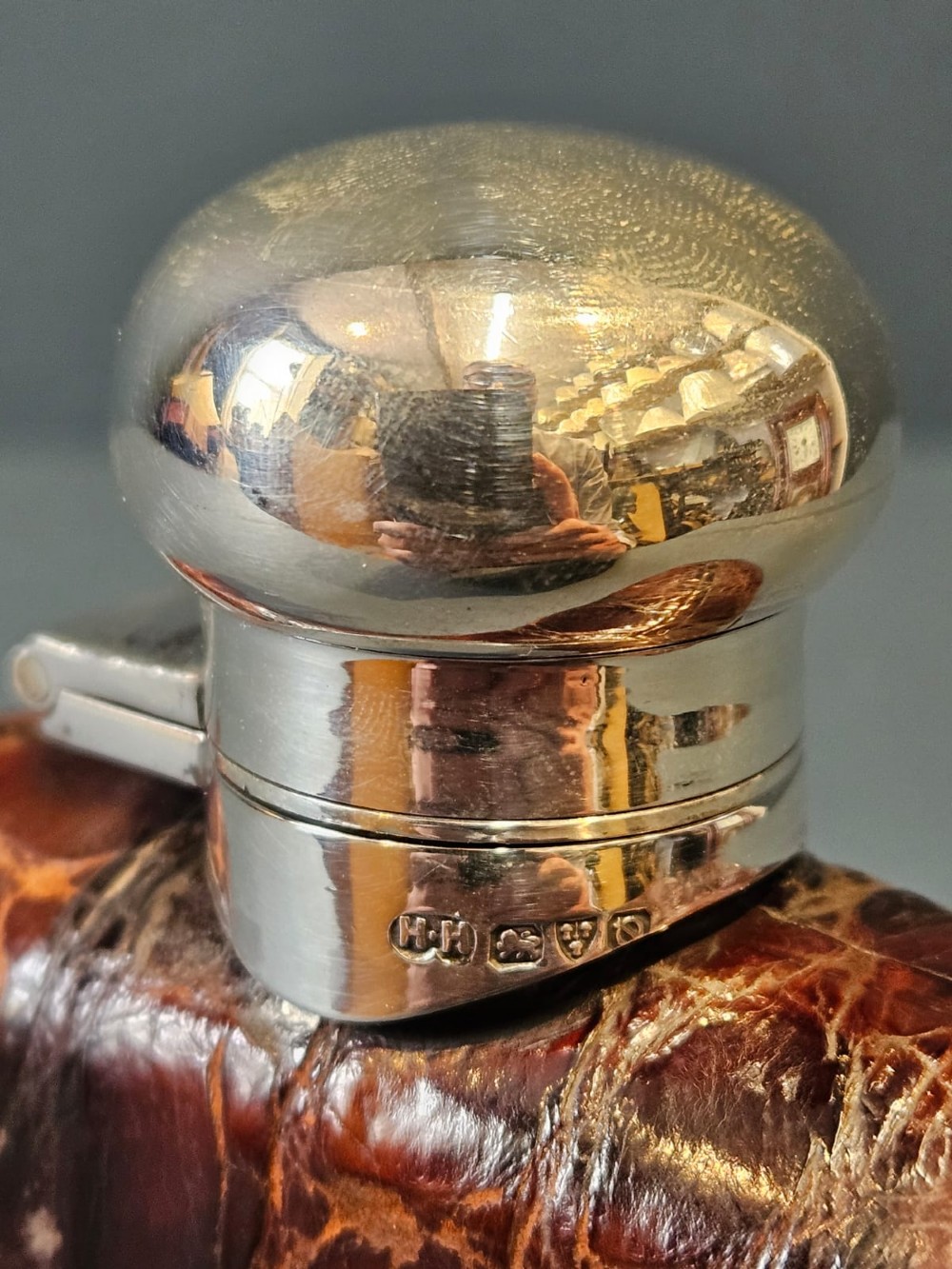 An antique silver hip flask partially encased in brown textured crocodile skin with a bayonet cap and removable base cup. View VII