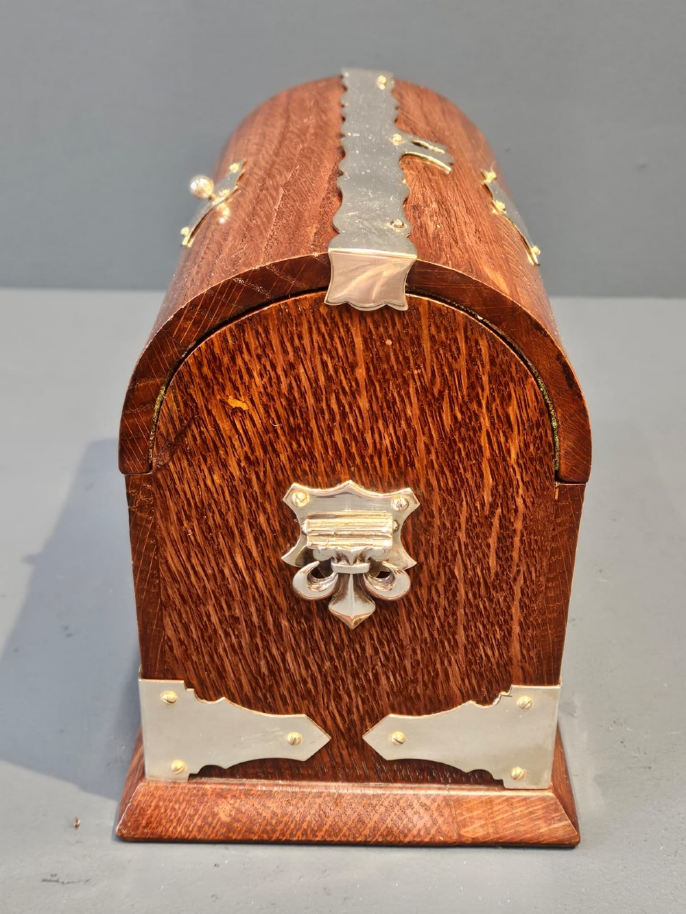A Victorian domed oak tea caddy featuring silver-plated corner mounts, an escutcheon, and side carrying handles. View III