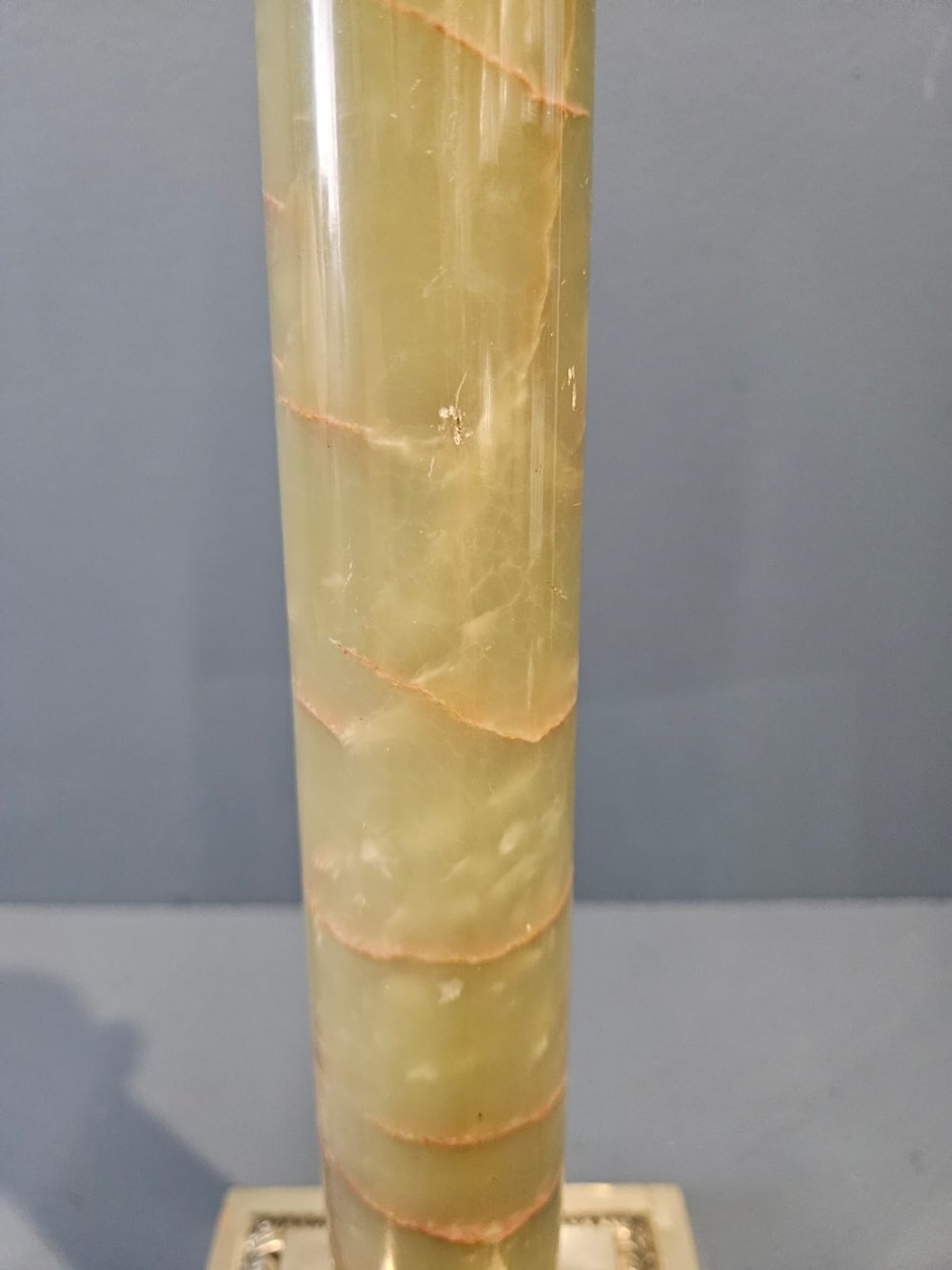 A late Victorian table lamp featuring a brass Corinthian capital, a cylindrical green marble shaft, and a square stepped brass base. View IV